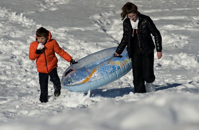 Ryker Fenton, 8, left, and his neighbor Heather Lalumondiere, 14, both of Front Royal, walk up a hill outside Warren County Middle School on Wednesday afternoon after a tubing ride. Warren and Shenandoah County students had Wednesday off and will get another day off today as area schools remain closed following last weekend's snow. Rich Cooley/Daily